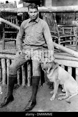 Agosto 5, 1945 - Manassa, CO, Stati Uniti - JACK DEMPSEY con il suo cane sul ranch. Jack 'Manassa Mauler" Dempsey (24 giugno 1895 - 31 Maggio 1983) era un pugile americano che ha tenuto il world heavyweight titolo dal 1919 al 1926. Dempsey's stile aggressivo e punzonatura power ha fatto di lui uno dei più popolari boxer nella storia. Molte delle sue lotte impostare finanziaria e record di partecipazione. FILE: c. 1920-40s. Foto Stock