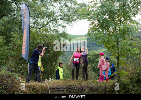 I concorrenti che posano per una foto prima di saltare in acqua /stagno durante gara Endurance testing stamina e fitness in Derbyshire Foto Stock