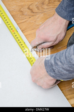 Mani maschio di misura e taglio di cartongesso Foto Stock