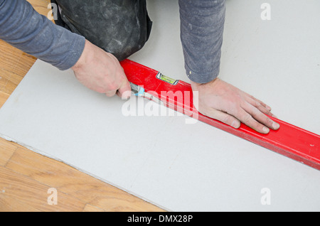 Mani maschio di misura e taglio di cartongesso Foto Stock