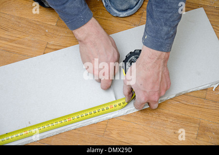 Mani maschio di misura e taglio di cartongesso Foto Stock