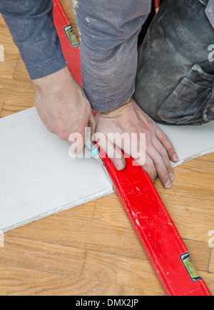 Mani maschio di misura e taglio di cartongesso Foto Stock