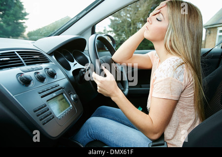 Ragazza la guida con un mal di testa Foto Stock