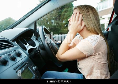 Ragazza la guida con un mal di testa Foto Stock