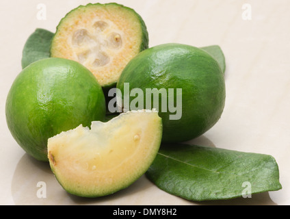 Ananas guaiava o feijoa frutti e foglie su un tavolo di marmo Foto Stock