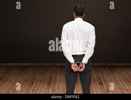 Immagine composita della vista posteriore del giovane imprenditore indossando le manette Foto Stock