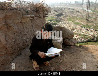 Peshawar. Xviii Dicembre, 2013. Un profugo afgano boy legge un libro sulla periferia del nord-ovest del Pakistan Peshawar a Dic. 18, 2013. Il 18 dicembre è il giorno in cui la comunità internazionale riconosce i diritti dei migranti di tutto il mondo. La giornata è stata ufficialmente designata come la Giornata Internazionale dei Migranti dalle Nazioni Unite nel 2000. © Ahmad Sidique/Xinhua/Alamy Live News Foto Stock