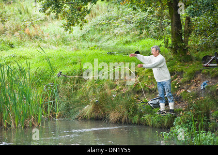 Il dragaggio di rifiuti al di fuori di un laghetto Foto Stock