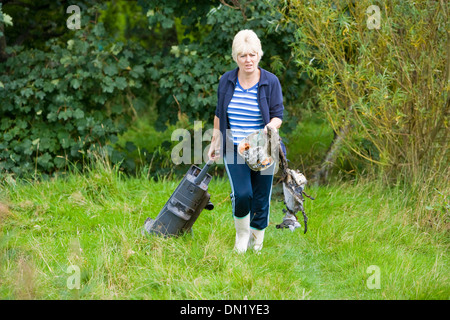 Rimozione di rifiuti da un laghetto Foto Stock