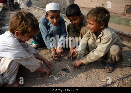 Peshawar. Xviii Dicembre, 2013. Profugo afgano ragazzi giocare su binari ferroviari sulla periferia del nord-ovest del Pakistan Peshawar a Dic. 18, 2013. Il 18 dicembre è il giorno in cui la comunità internazionale riconosce i diritti dei migranti di tutto il mondo. La giornata è stata ufficialmente designata come la Giornata Internazionale dei Migranti dalle Nazioni Unite nel 2000. © Ahmad Sidique/Xinhua/Alamy Live News Foto Stock