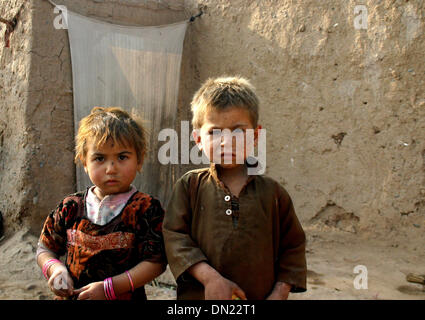 Peshawar. Xviii Dicembre, 2013. Profugo afgano bambini posano per una foto davanti alla loro casa di fortuna alla periferia del nord-ovest del Pakistan Peshawar a Dic. 18, 2013. Il 18 dicembre è il giorno in cui la comunità internazionale riconosce i diritti dei migranti di tutto il mondo. La giornata è stata ufficialmente designata come la Giornata Internazionale dei Migranti dalle Nazioni Unite nel 2000. © Ahmad Sidique/Xinhua/Alamy Live News Foto Stock