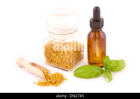 Essiccato caledula officinalis petali con olio macerato isolato su bianco Foto Stock