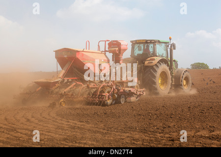 Terreno polveroso vola da ruote e attrezzature come un trattore trapani seme in un campo. Foto Stock