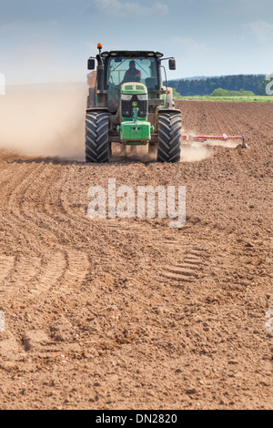 Terreno polveroso vola da ruote e attrezzature come un trattore trapani seme in un campo. Foto Stock