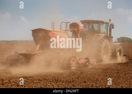 Terreno polveroso vola da ruote e attrezzature come un trattore trapani seme in un campo. Foto Stock