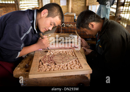 Il Bhutan, Bumthang Kurjey Lhakang monastero, artigiani carving pannello di legno Foto Stock