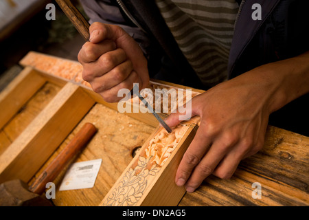 Il Bhutan, Bumthang Kurjey Lhakang monastero, mani di artigiano carving pannello di legno Foto Stock