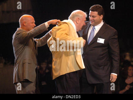 Aug 04, 2006; Cantone, OH, Stati Uniti d'America; Mike e Joe Madden, destra, aiutare i loro papà Giovanni con il suo giallo Pro Football Hall of Fame camicia durante la cena Enshinees nel Canton Ohio giovedì agosto 4,2006. Credito: Foto di Bob Larson/Contra Costa Times/ZUMA premere. (©) Copyright 2006 by Contra Costa Times Foto Stock