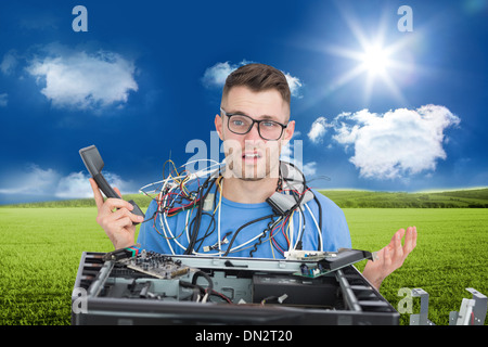 Immagine composita di confuse it professional con cavi e telefono nella parte anteriore della cpu aperto Foto Stock