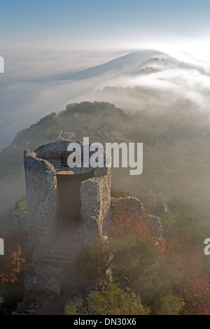Sunrise oltre il Castillo de Monfrague con laminazione nebbia sulle colline Foto Stock