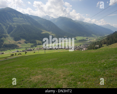 Panoramica del villaggio Munster nel distretto di Goms nelle alpi svizzere e da un trekking lungo il fianco della montagna Foto Stock