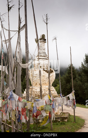 Il Bhutan orientale, Shertang La Pass, bandiere di preghiera e antico in pietra dipinta di bianco chorten Foto Stock