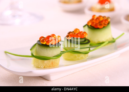 Caviale rosso su cetriolo fresco come snack, close up Foto Stock