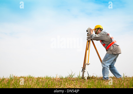 Ingegnere geometra facendo misurare sul campo Foto Stock