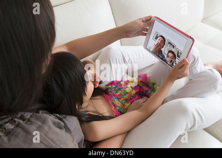 Asian madre e figlia di parlare di famiglia sulla tavoletta digitale Foto Stock