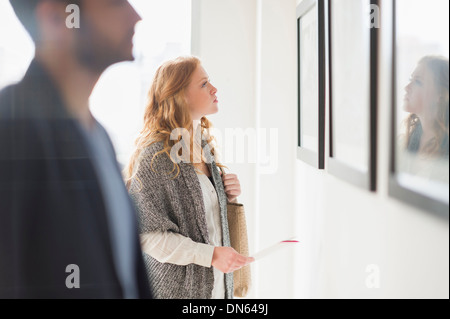 Donna ammirando arte in galleria Foto Stock