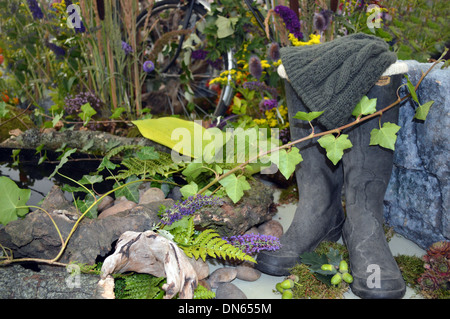 Stivali e cappello di lana (Compo) in un arte floreale Display di ultima del vino estivo da Acomb Flower Guild a Harrogate Autunno Mostra Foto Stock