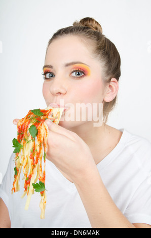 Donna mangiare spaghetti tenendolo in mano Foto Stock