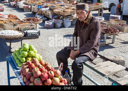 L'uomo vendita di mele in un mercato all'aperto, vicino a Samarcanda, Uzbekistan Foto Stock
