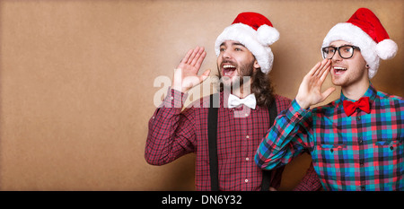 Due ragazzi in hipster vestiti di Babbo Natale in un grido di Natale Foto Stock