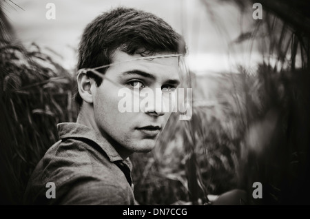 Giovane uomo in piedi in cornfield, ritratto Foto Stock