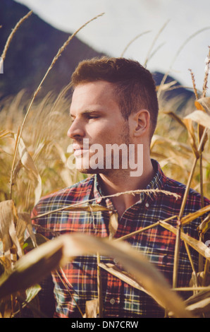 Giovane uomo in piedi in cornfield, ritratto Foto Stock