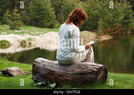 La donna la lettura di un libro digitale Foto Stock