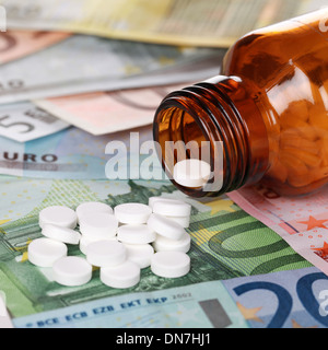 Immagine simbolica per l alto costo della sanità con la medicina sulle banconote in euro Foto Stock