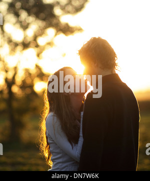 Amare giovane kissing in controluce Foto Stock