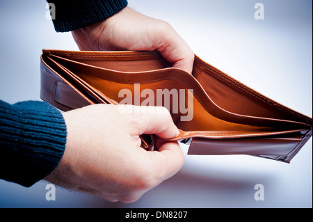 Uomo che mostra un portafoglio vuoto Foto Stock