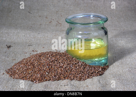 L'olio di lino e il lino semi del sullo sfondo della tela Foto Stock