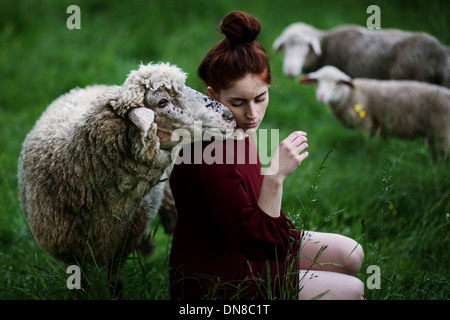 Giovane donna con pecora su un prato Foto Stock