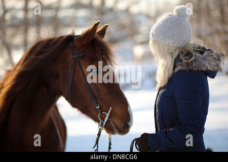 Giovane donna con cavallo in inverno Foto Stock