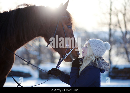 Giovane donna con cavallo in inverno Foto Stock