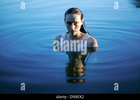 Giovane donna in piedi in acqua, ritratto Foto Stock