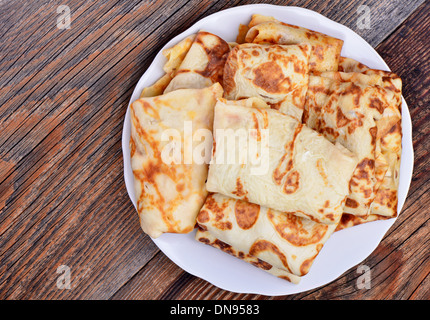 Frittelle e una tazza di tè su sfondo di legno Foto Stock