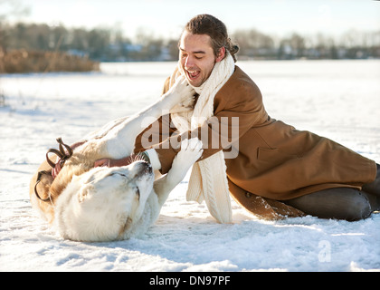 Uomo e dell Asia centrale pastore giocando con il suo cane all'aperto Foto Stock