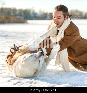 Uomo e dell Asia centrale pastore giocando con il suo cane all'aperto Foto Stock