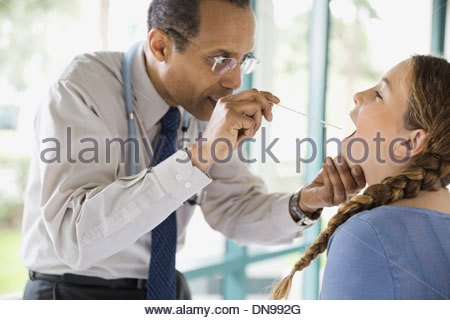Medico di esaminare la ragazza con abbassa lingua