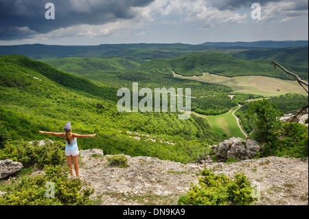 Giovane donna godendo la tempesta sul bordo della scogliera, Crimea, Ucraina Foto Stock